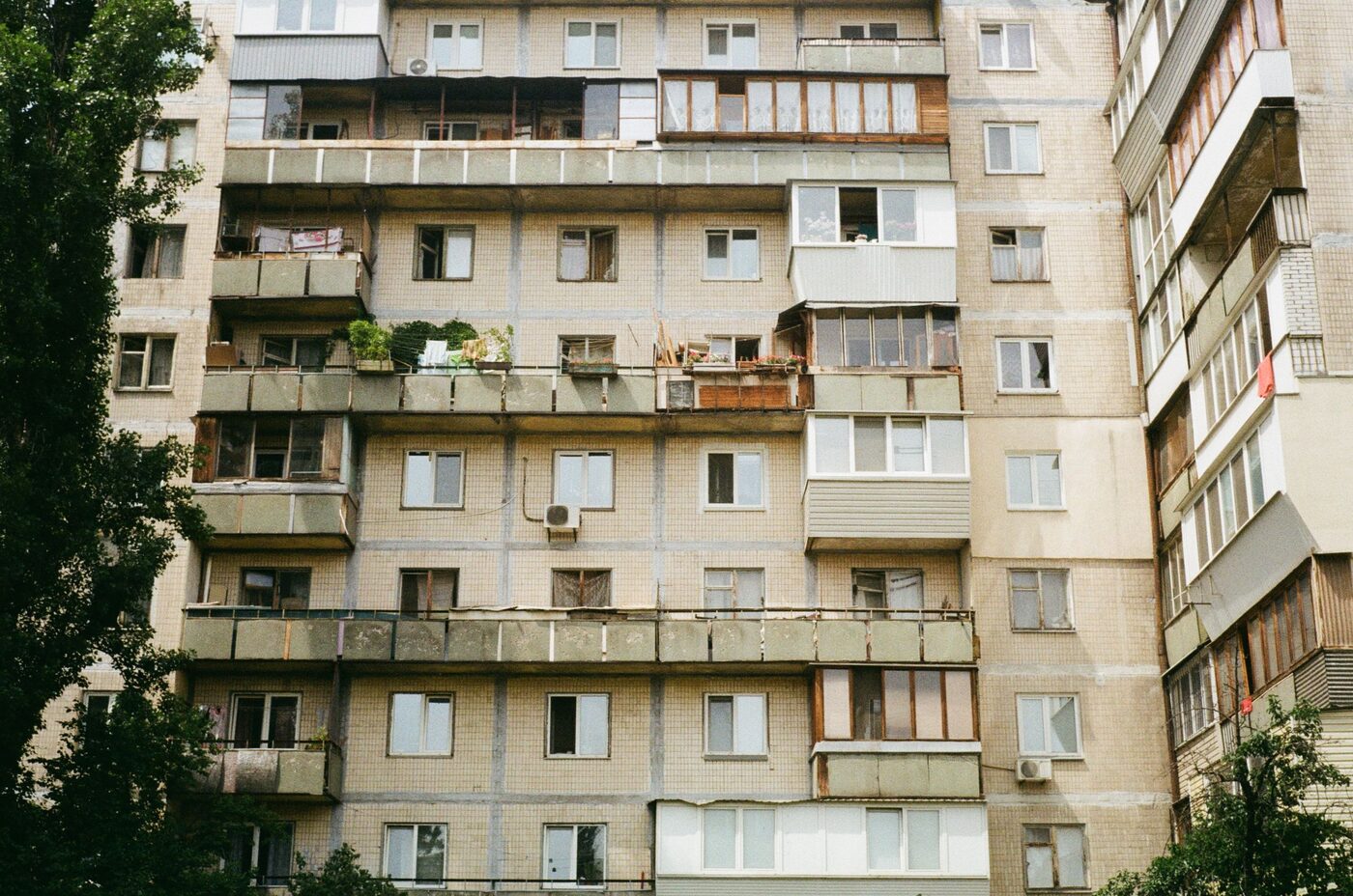 Panelový dům s řadou oken a lodžií do ulice