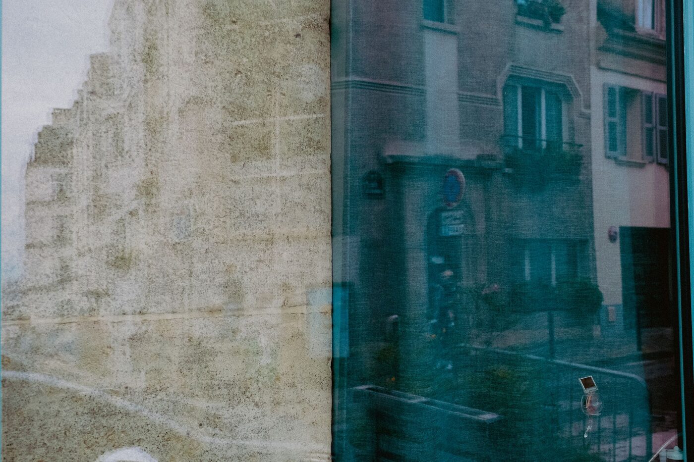 Ulice a protější domy odražené v okenním skle